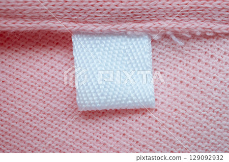 White blank laundry care clothes label on pink shirt fabric background White blank laundry care clothes label on pink shirt fabric background 129092932