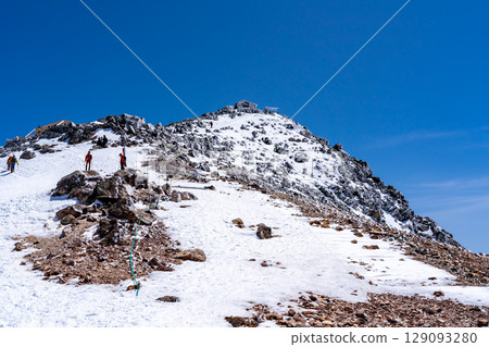 Looking up at the peak of Mt. Norikura's Kengamine peak. Climbing Mt. Norikura in the Northern Alps during Golden Week when snow remains. 129093280