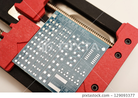 Universal professional holder for circuit boards and microchips. Blue printed circuit board for soldering. 129093377