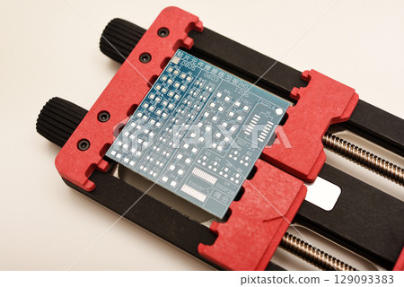 Universal professional holder for circuit boards and microchips. Blue printed circuit board for soldering. 129093383