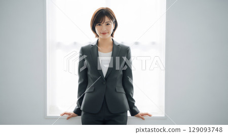Portrait of a smiling female business person in a room filled with natural light 129093748