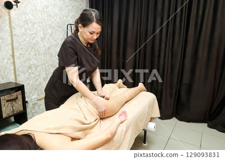 An invigorating, intense hot stone massage of the legs and buttocks 129093831