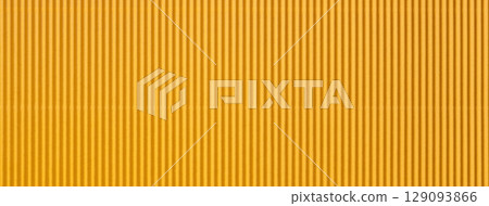 Corrugated yellow paper texture with vertical stripes in golden and orange colors, macro background 129093866