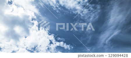 Blue Sky with Fluffy White Clouds on a Clear Day 129094428