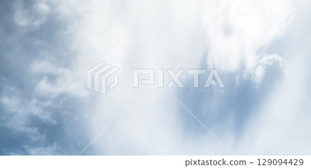 Bright Blue Sky with White Fluffy Clouds in a Sunny Atmosphere 129094429