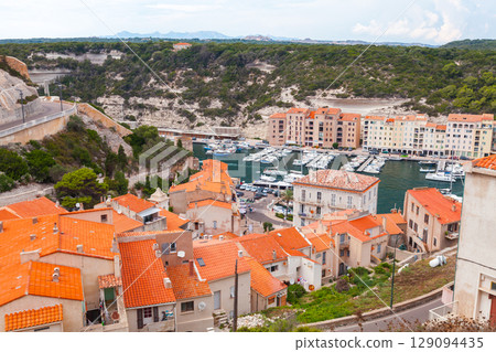 Picturesque Coastal Village with Red-Tiled Roofs and Harbor Marina View 129094435