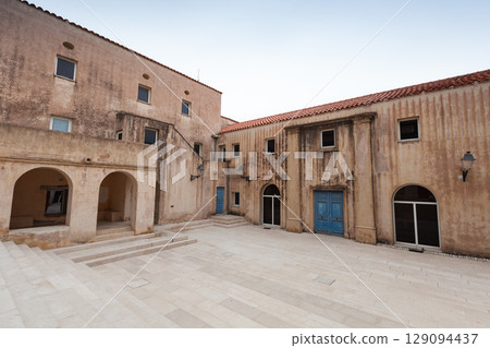 Historic Building Courtyard With Rustic Exterior and Stone Pavement Historic Building Courtyard With Rustic Exterior and Stone Pavement 129094437