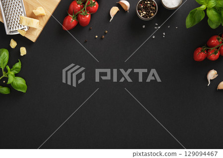 Fresh Italian ingredients like cherry tomatoes, garlic, basil, cheese, salt, and pepper on black background Fresh Italian ingredients like cherry tomatoes, garlic, basil, cheese, salt, and pepper on black background 129094467