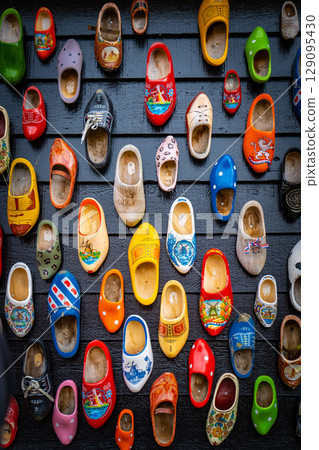 Wooden shoes painted with different regional motifs. Wooden clogs, typical traditional footwear from the Netherlands. 129095430