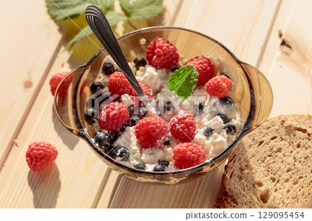 Cottage cheese with fresh raspberries and blueberries. Cottage cheese with fresh raspberries and blueberries. 129095454