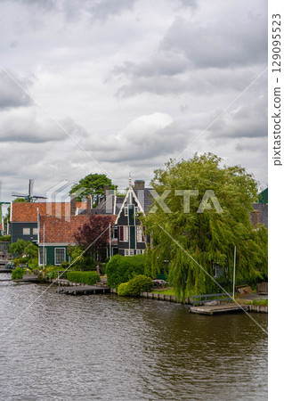 Rural landscape with windmill in Zaanse Schans. Holland, Netherlands. Authentic Zaandam mill. Beautiful Netherland landscape. 129095523