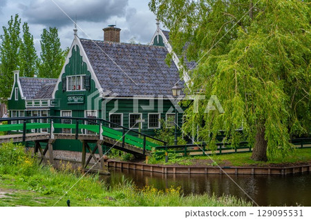 Rural landscape with windmill in Zaanse Schans. Holland, Netherlands. Authentic Zaandam mill. Beautiful Netherland landscape. Rural landscape with windmill in Zaanse Schans. Holland, Netherlands. Authentic Zaandam mill. Beautiful Netherland landscape. 129095531