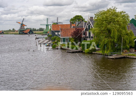 Rural landscape with windmill in Zaanse Schans. Holland, Netherlands. Authentic Zaandam mill. Beautiful Netherland landscape. 129095563
