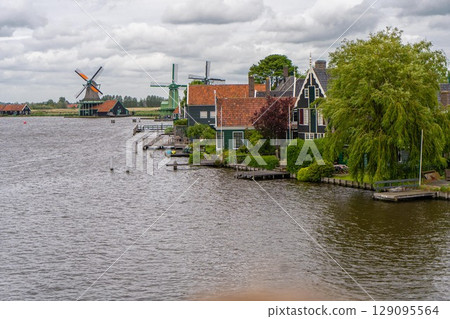 Rural landscape with windmill in Zaanse Schans. Holland, Netherlands. Authentic Zaandam mill. Beautiful Netherland landscape. Rural landscape with windmill in Zaanse Schans. Holland, Netherlands. Authentic Zaandam mill. Beautiful Netherland landscape. 129095564