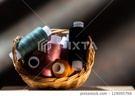 Various sewing threads in a straw basket. 129095766