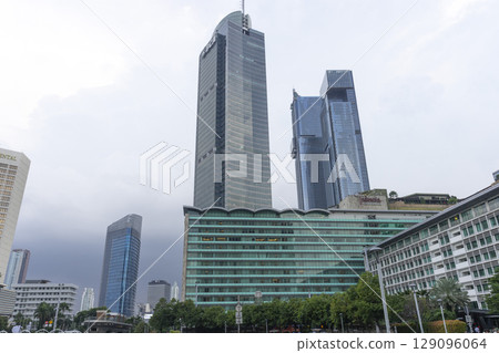 Jakarta, Indonesia - Mar 30,2024 : View of Bundaran HI along Jendral Sudirman road in Jakarta, Indonesia on Mar 30,2024. Jakarta, Indonesia - Mar 30,2024 : View of Bundaran HI along Jendral Sudirman road in Jakarta, Indonesia on Mar 30,2024. 129096064