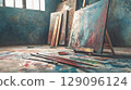 Artistic setup featuring a painting easel with vibrant oil paints and brushes against a textured grunge background, creative workspace atmosphere 129096124