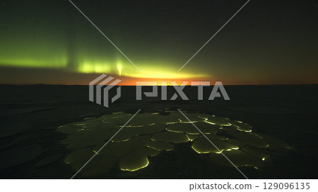 Stunning aurora borealis lighting up the dark night sky above a frozen lake, creating a magical and serene winter landscape Stunning aurora borealis lighting up the dark night sky above a frozen lake, creating a magical and serene winter landscape 129096135