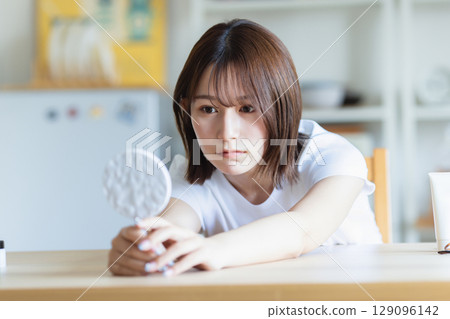 A woman looking at a mirror A woman looking at a mirror 129096142