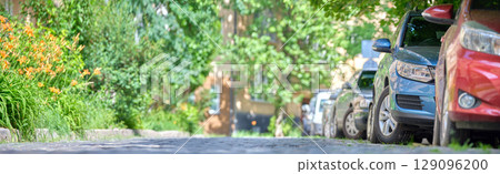City traffic with cars parked in line on street side. 129096200