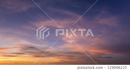 Bright sunset with setting sun behind vivid orange and yellow clouds Bright sunset with setting sun behind vivid orange and yellow clouds 129096225
