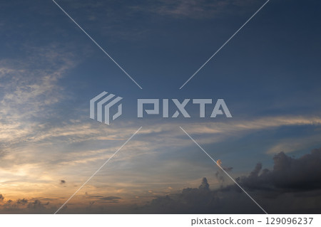 Bright colorful orange and yellow clouds on horizon. Beautiful sunset sky scenery 129096237