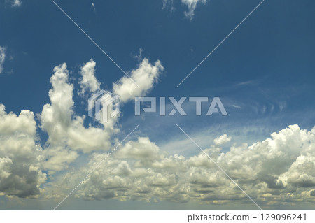 Blue sky with white summer rain clouds. Colorful summer landscape Blue sky with white summer rain clouds. Colorful summer landscape 129096241
