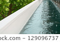 Outdoor swimming pool with lush green trees and fresh water in summer 129096737