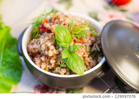 simple dinner. Cooked buckwheat with vegetables in a ceramic bowl simple dinner. Cooked buckwheat with vegetables in a ceramic bowl 129097076
