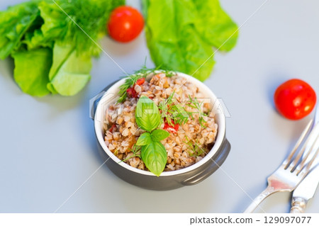 Buckwheat dinner with vegetables on a gray background Buckwheat dinner with vegetables on a gray background 129097077