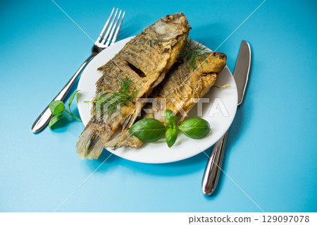 Homemade dish - golden crucian carp on a plate with spices 129097078