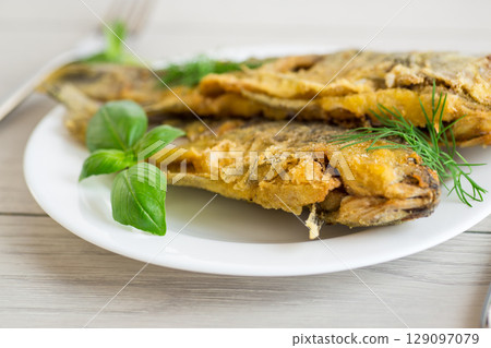 Traditional Ukrainian fried crucian carp in a village kitchen 129097079