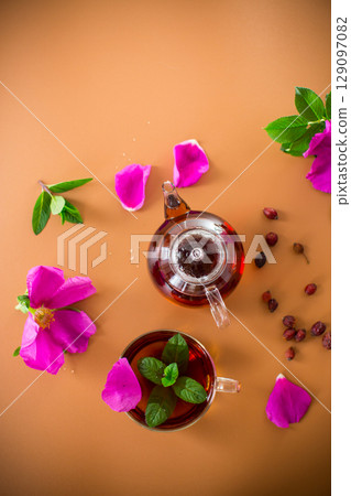 Aesthetic serving of tea with rosehip, petals and mint greens 129097082