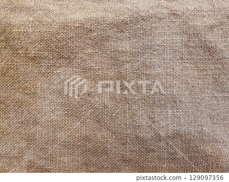 Rural texture of sackcloth. Background of very coarse, rough fabric woven made of flax, jute or hemp. Burlap bag material. Design element. 129097356