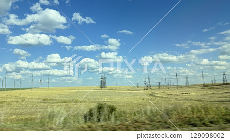 Many high-voltage transmission tower and electricity pylon power lines against blue sky with cloud 129098002