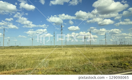 Many high-voltage transmission tower and electricity pylon power lines against blue sky with cloud 129098065