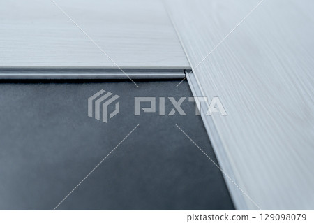 A man lays a quartz laminate on the floor. Renovation, Installation of French herringbone A man lays a quartz laminate on the floor. Renovation, Installation of French herringbone 129098079
