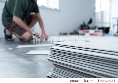 A man lays a quartz laminate on the floor. Renovation, Installation of French herringbone 129098081