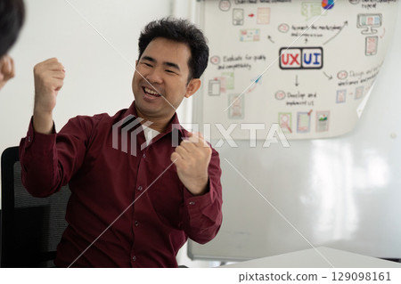 UX and UI Design Enthusiasm. Team member celebrating successful collaboration in design. 129098161