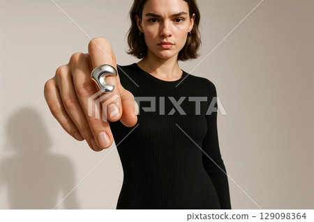 Confident Woman with Silver Ring Pointing Directly at Camera 129098364