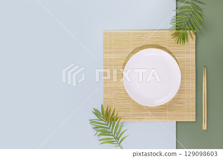 Eco friendly Mock up for display or montage of dishes or food. Minimalistic, oriental style composition with an empty plate on nature mat with wooden chopsticks and palm leaves. Flat lay, copy space 129098603