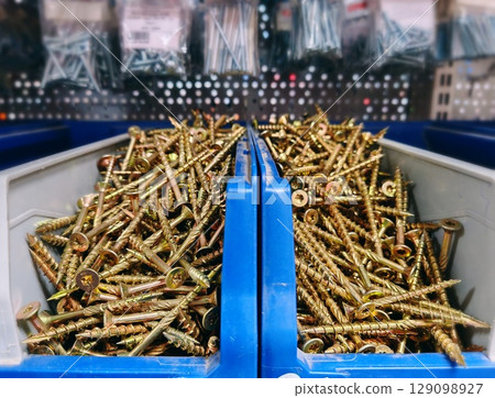different types of screws stored in organized bins in a hardware store aisle. Screws organized storage. different types of screws stored in organized bins in a hardware store aisle. Screws organized storage. 129098927