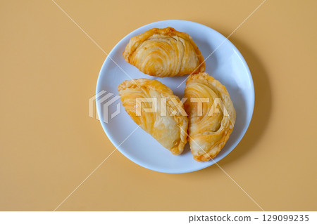 Thai Curry puff,puff pastry stuffed chicken on plate. 129099235