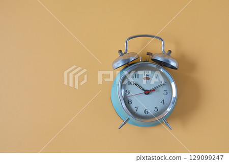 Old alarm clock with bell on the top, antique classic alarm clock. 129099247