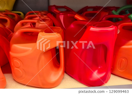 Colorful plastic containers lined up on a shelf in a store 129099463