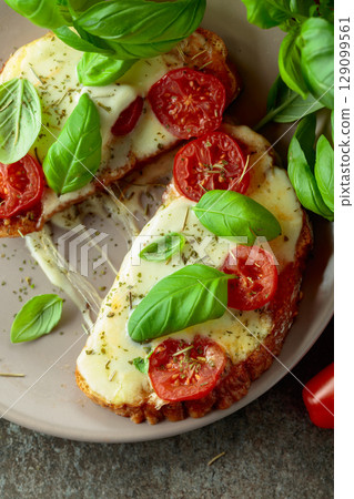 Hot open sandwiches with mozzarella, tomatoes and basil. 129099561
