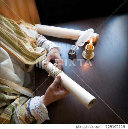 Man holding an old scroll Man holding an old scroll 129100219