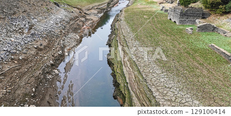 Dry riverbed, with arid and cracked soil because of drought, due to climate change Dry riverbed, with arid and cracked soil because of drought, due to climate change 129100414