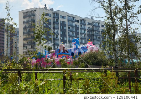 A lively and vibrant playground scene that showcases colorful inflatables in an urban setting 129100441