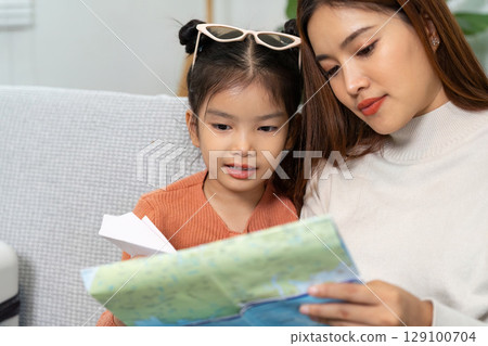 Travel Planning. A mother and daughter reviewing a map, excited for their upcoming trip. Travel Planning. A mother and daughter reviewing a map, excited for their upcoming trip. 129100704